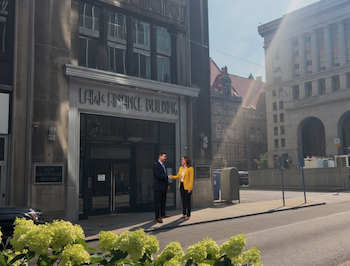 Lawyer greeting a client in front of the Law & Finance Building across the street from the City-County Building